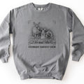 Overnight Harvest Crew Comfort Colors crewneck sweatshirt in Grey, laid flat. A black ink sketch of a deer with a leaf in its mouth beside a rabbit and a groundhog holding carrots among cabbages, within corner brackets above the words OVERNIGHT HARVEST CREW. On a white surface.