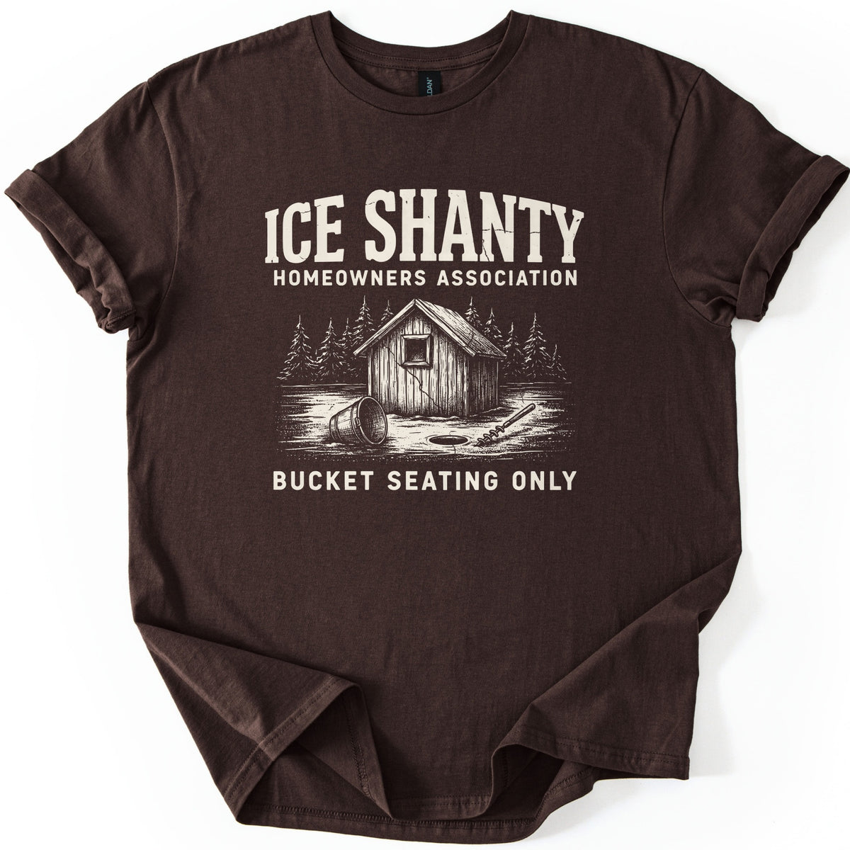 Ice Shanty Homeowners Association Comfort Colors T-shirt in Dark Chocolate, laid flat. Cream print reads ICE SHANTY, HOMEOWNERS ASSOCIATION above a sketch of a wooden ice shack among pines with a tipped bucket, ice hole and auger, then BUCKET SEATING ONLY. Sleeves cuffed, on white.