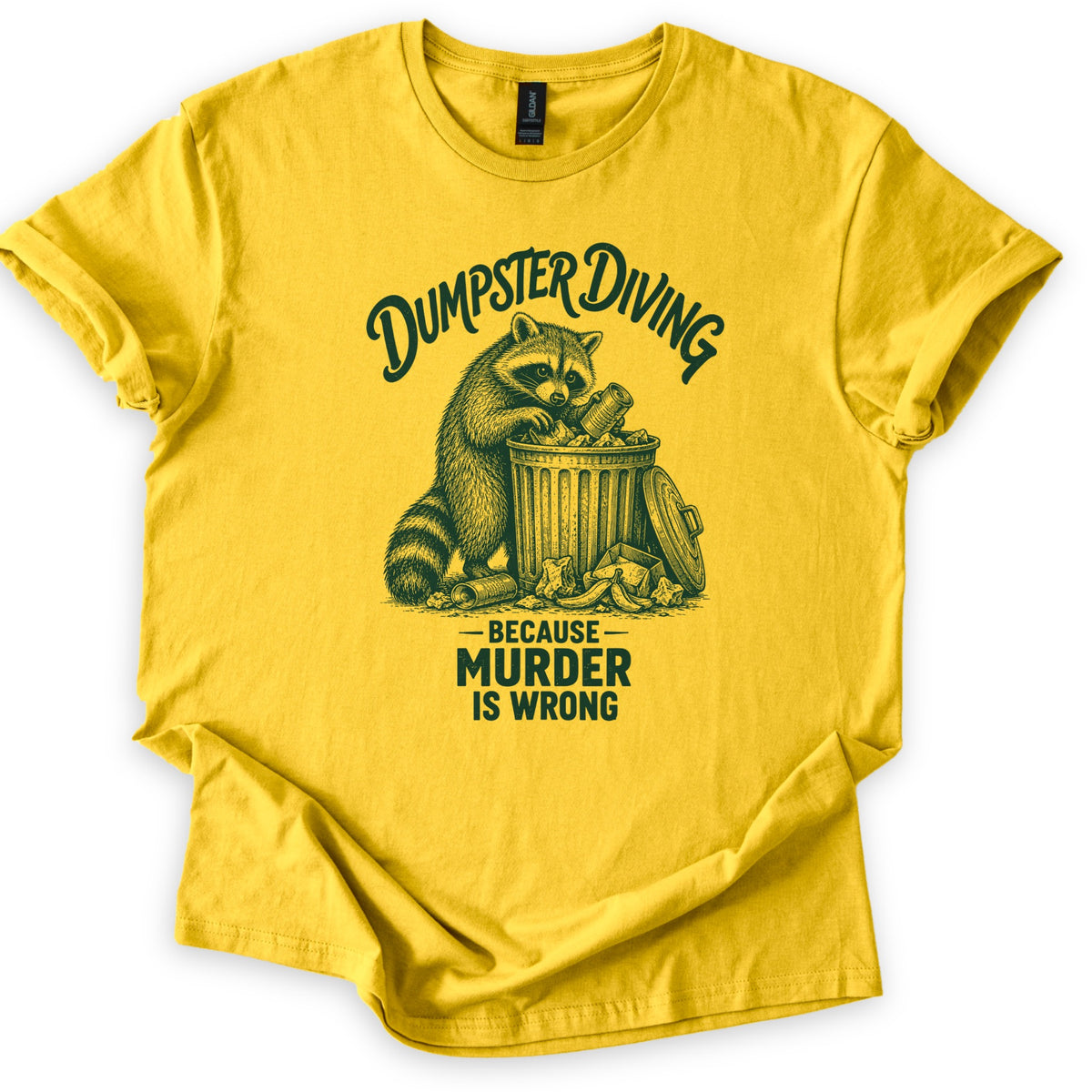 Dumpster Diving Murder Raccoon Comfort Colors T-shirt in Daisy, laid flat. Dark green etching of a raccoon digging through an overflowing trash can under arched script reading Dumpster Diving, with Because Murder Is Wrong below. Sleeves rolled on a white background.