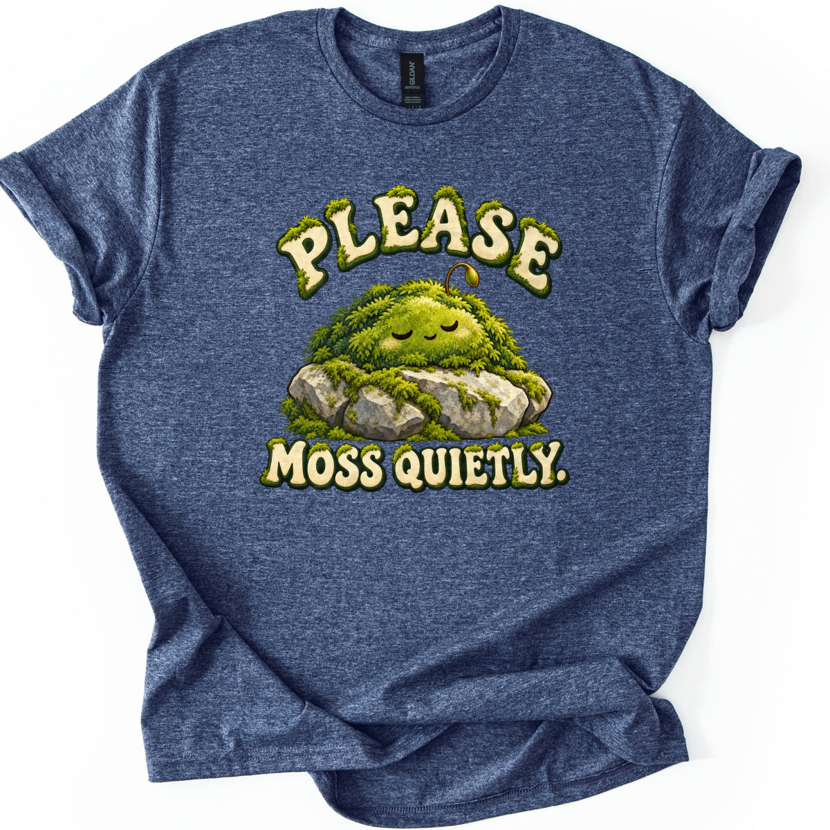 Please Moss Quietly Comfort Colors T-shirt in Heather Navy, laid flat. A sleepy, smiling mound of green moss with a tiny sprout rests on gray rocks between the words Please Moss Quietly. in cream letters edged with moss. The sleeves are rolled on a white background.