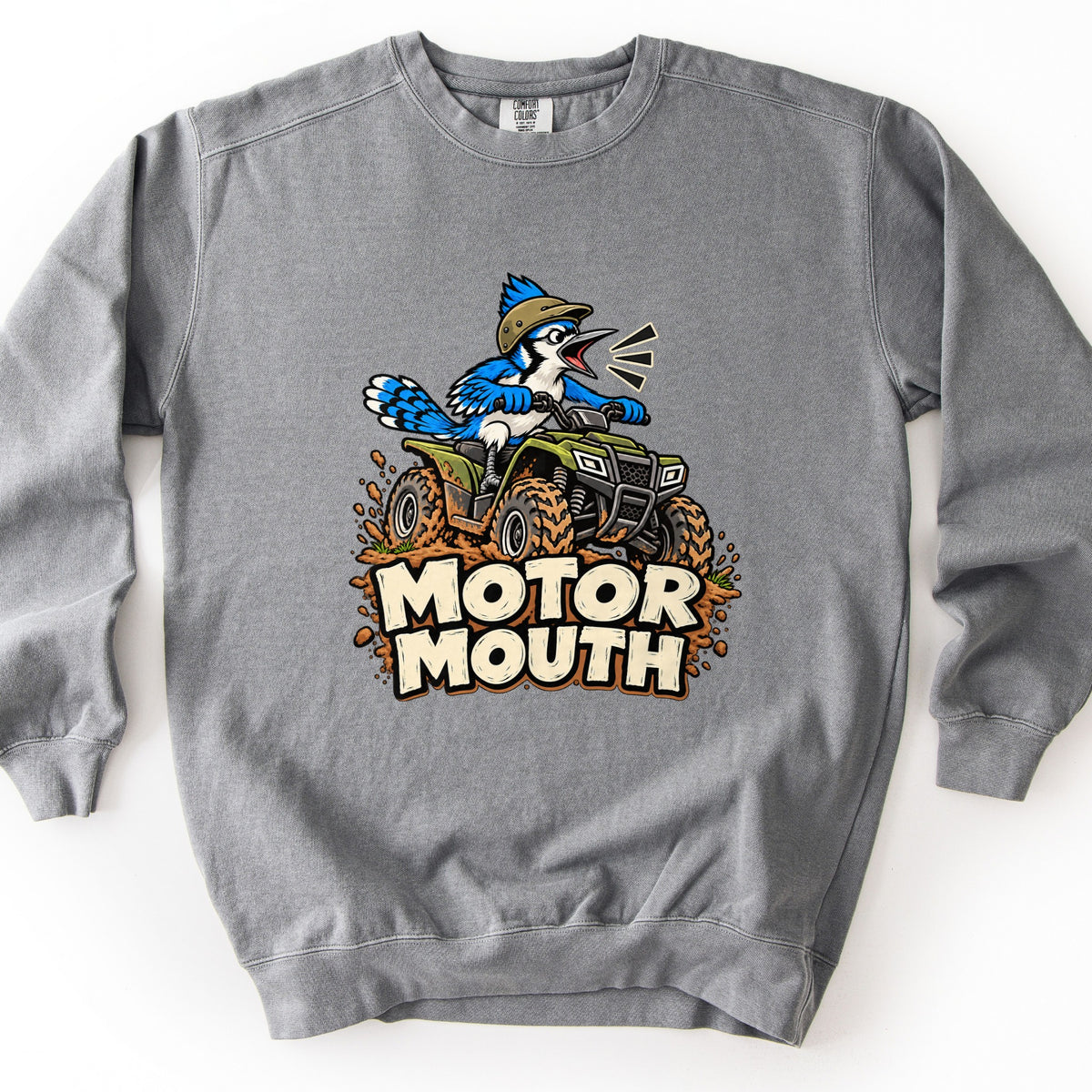 Motor Mouth Comfort Colors crewneck sweatshirt in Grey, laid flat. A cartoon blue jay in a tan helmet squawks while riding a green ATV through splattering mud above the words Motor Mouth in cream block letters. Shown on a white background.