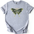 Luna Moth Night Comfort Colors T-shirt in Sport Grey, laid flat. A large green luna moth is printed on the chest, its wings filled with a night forest scene of trees, a meadow and a crescent moon. No words are printed. The shirt has rolled sleeves on a white background.