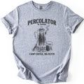 Percolator & Sons Comfort Colors T-shirt in Sport Grey, laid flat. A sketched coffee percolator steams on a grate over a campfire beside a tin cup, under the words Percolator & Sons and above Camp Coffee, No Filter, in black ink. The sleeves are rolled on a white background.