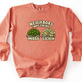 Neighbors Not Twins Comfort Colors crewneck sweatshirt in Terracotta, laid flat. Cream retro letters read Neighbors Not Twins above two rocks, one topped with green moss and two spore stalks labeled Moss, the other with ruffled pale green lichen labeled Lichen. On a white background.