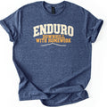 Enduro Downhill With Homework Comfort Colors T-shirt in Heather Navy, laid flat. Large arched cream varsity letters read ENDURO above orange text reading DOWNHILL WITH HOMEWORK, with a thin cream mountain ridge line below. The shirt has cuffed sleeves on a white background.