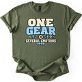 One Gear Several Emotions Comfort Colors T-shirt in Military Green, laid flat. One Gear in large cream and light blue block letters sits above a small gear flanked by exclamation and question marks, then Several Emotions and MTB. Cuffed sleeves on a white background.