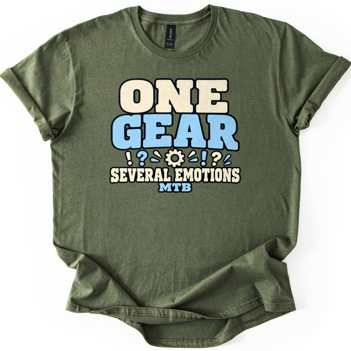 One Gear Several Emotions Comfort Colors T-shirt in Military Green, laid flat. One Gear in large cream and light blue block letters sits above a small gear flanked by exclamation and question marks, then Several Emotions and MTB. Cuffed sleeves on a white background.