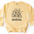 My Kind Of Hashtag Comfort Colors crewneck sweatshirt in Butter, laid flat. A black sketch of split firewood logs stacked into a hashtag symbol, with an axe stuck in a stump beside it, above the words My Kind Of Hashtag. The sweatshirt lies on a white background.