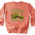 Taking the Scenic Inch Comfort Colors crewneck sweatshirt in Terracotta, laid flat. A cartoon snail with a moss-covered shell crawls along a mossy log between the words Taking the Scenic Inch. in cream letters dripping with green moss. The sweatshirt lies on a white surface.