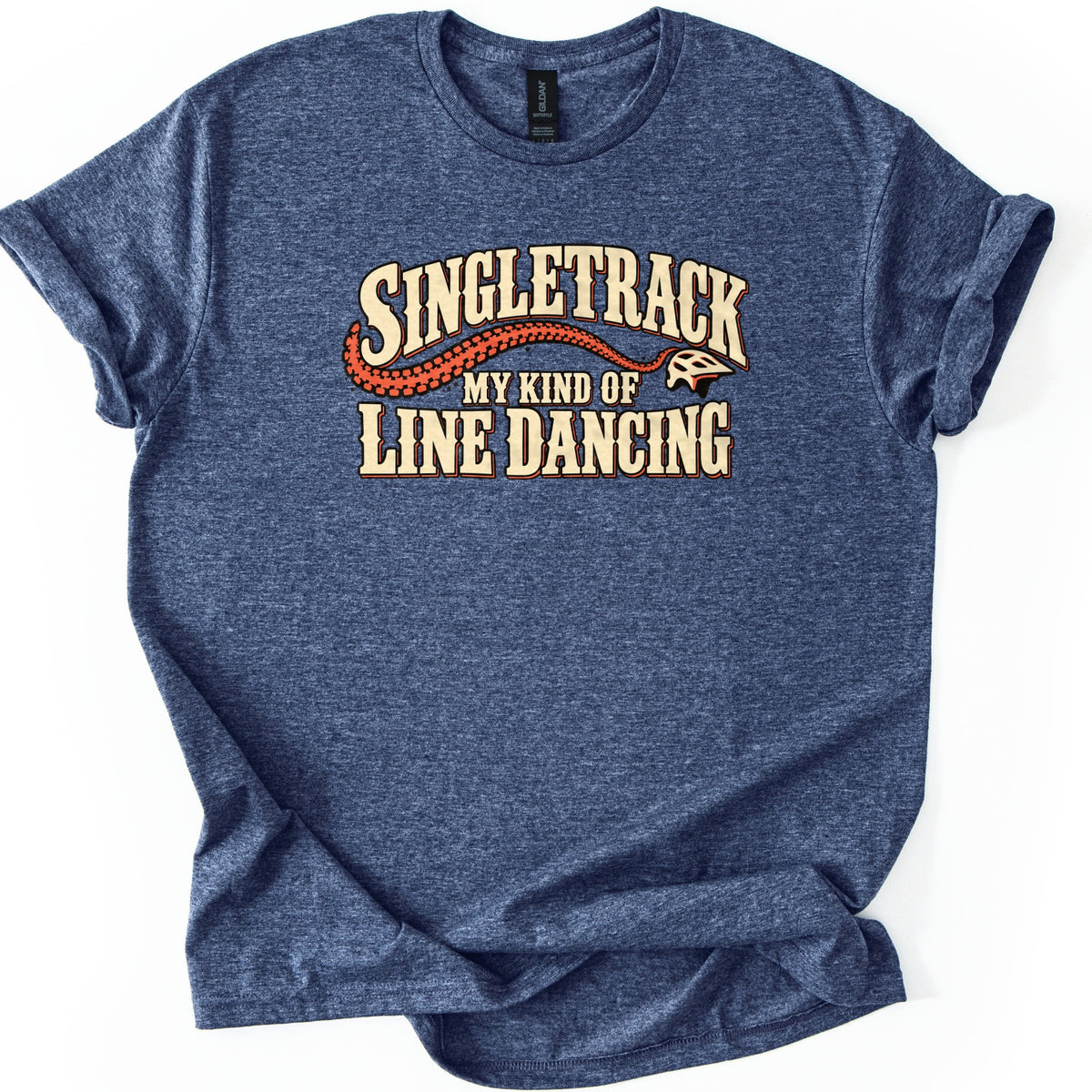 Singletrack My Kind of Line Dancing Comfort Colors T-shirt in Heather Navy, laid flat. Cream western-style letters spell Singletrack over an orange tire track that curves to a bike helmet, above the words My Kind of Line Dancing. The shirt has rolled sleeves on a white background.