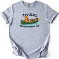 Important Dog Comfort Colors T-shirt in Sport Grey, laid flat. A golden retriever in an orange life vest sits in a green canoe with a paddle on blue water, between the words Two Seats and One Very Important Dog. The shirt lies on a white background with cuffed sleeves.
