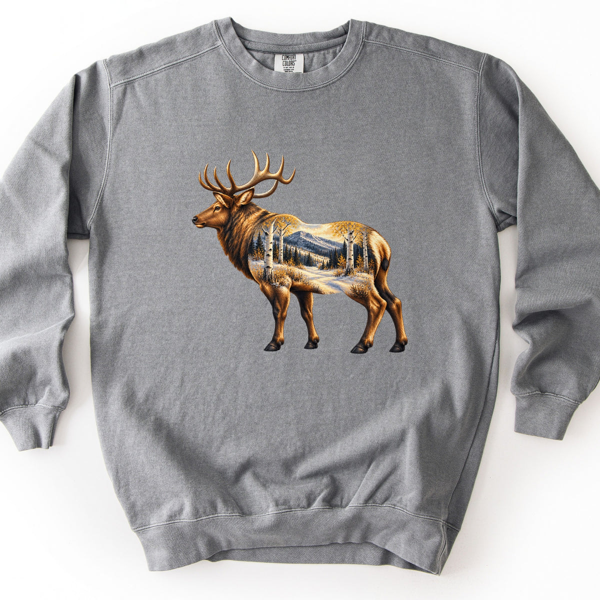 Aspen Pass Elk Comfort Colors crewneck sweatshirt in Grey, laid flat. A painted bull elk with large antlers stands facing left, its body filled with a scene of white aspen trees, golden leaves, snowy ground and a mountain. No words are printed. Shown on a white surface.