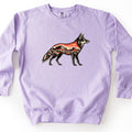 Desert Mesa Coyote Comfort Colors crewneck sweatshirt in Orchid, laid flat. A coyote in profile filled with a desert scene of red mesas, a sunset sky and sagebrush, with no words printed. The sweatshirt lies on a plain white surface with sleeves spread out at the sides.
