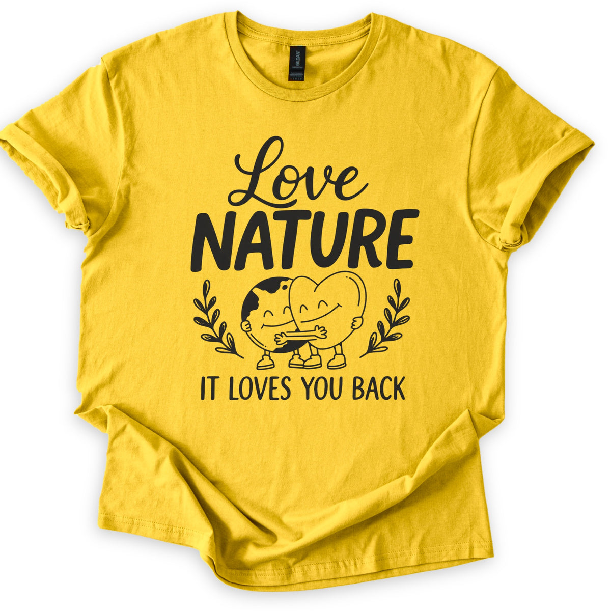Nature Loves You Back Comfort Colors T-shirt in Daisy, laid flat. Black print reads Love NATURE above a smiling cartoon Earth and heart hugging between two leafy sprigs, then IT LOVES YOU BACK. The sleeves are rolled and the shirt lies on a white background.