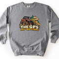The GPS Has Questions Comfort Colors crewneck sweatshirt in Grey, laid flat. A cartoon orange side-by-side off-road vehicle splattered with mud climbs a rocky dirt trail past a wooden signpost and pine trees, above the words The GPS Has Questions. Laid on a white surface.