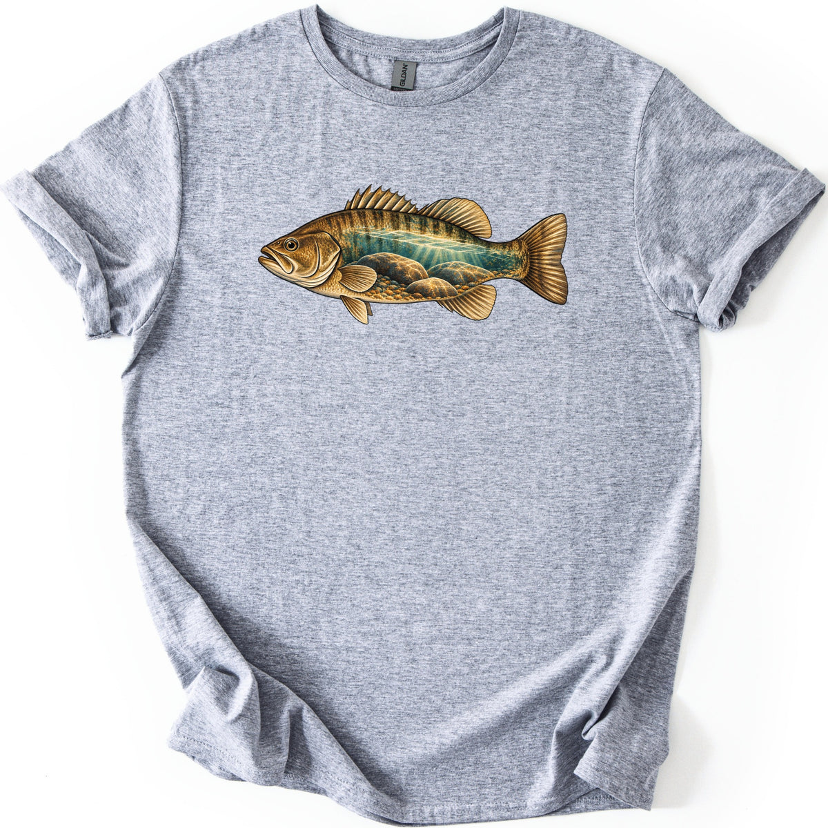 Rocky Shallows Bass Comfort Colors T-shirt in Sport Grey, laid flat. A gold and brown bass is printed across the chest, its body filled with an underwater scene of teal water, light rays and rounded rocks. No words are printed. The shirt has rolled sleeves on a white background.