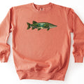 Pike Weed Bed Comfort Colors crewneck sweatshirt in Terracotta, laid flat. A northern pike printed across the chest, its body filled with a sunlit underwater scene of green weeds and a sandy path, edged with pale spots and gold fins. No words are printed. Shown on a white background.