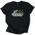 Cast and Cruise Comfort Colors T-shirt in Black, laid flat. A trout leaps from splashing teal water beside a four-wheeler ATV with a fishing rod on rocky ground, above the words Cast and Cruise. The shirt has rolled sleeves on a white background.