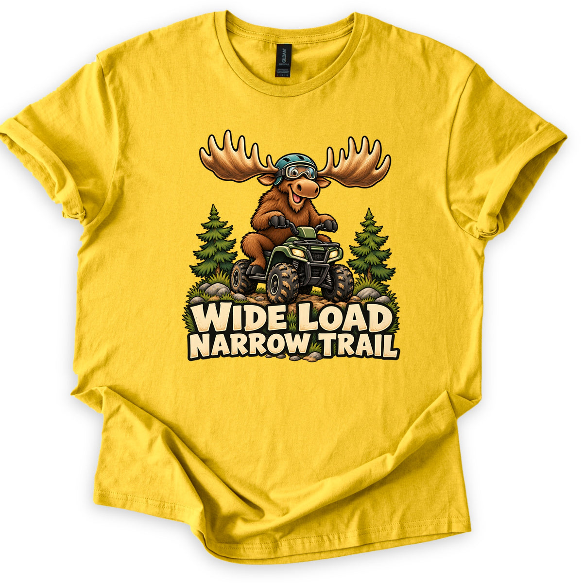 Wide Load Narrow Trail Comfort Colors T-shirt in Daisy, laid flat. A cartoon moose with huge antlers, a helmet and goggles rides a green ATV on a dirt trail between pine trees above the words Wide Load Narrow Trail. The shirt lies on a white background with cuffed sleeves.