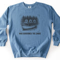 Who Borrowed The Canoe Comfort Colors crewneck sweatshirt in Blue Jean, laid flat. A black sketch of three otters in a canoe on a lake, one holding a lantern and two holding paddles, with pine trees behind and corner brackets around it. Below it reads WHO BORROWED THE CANOE. On white.