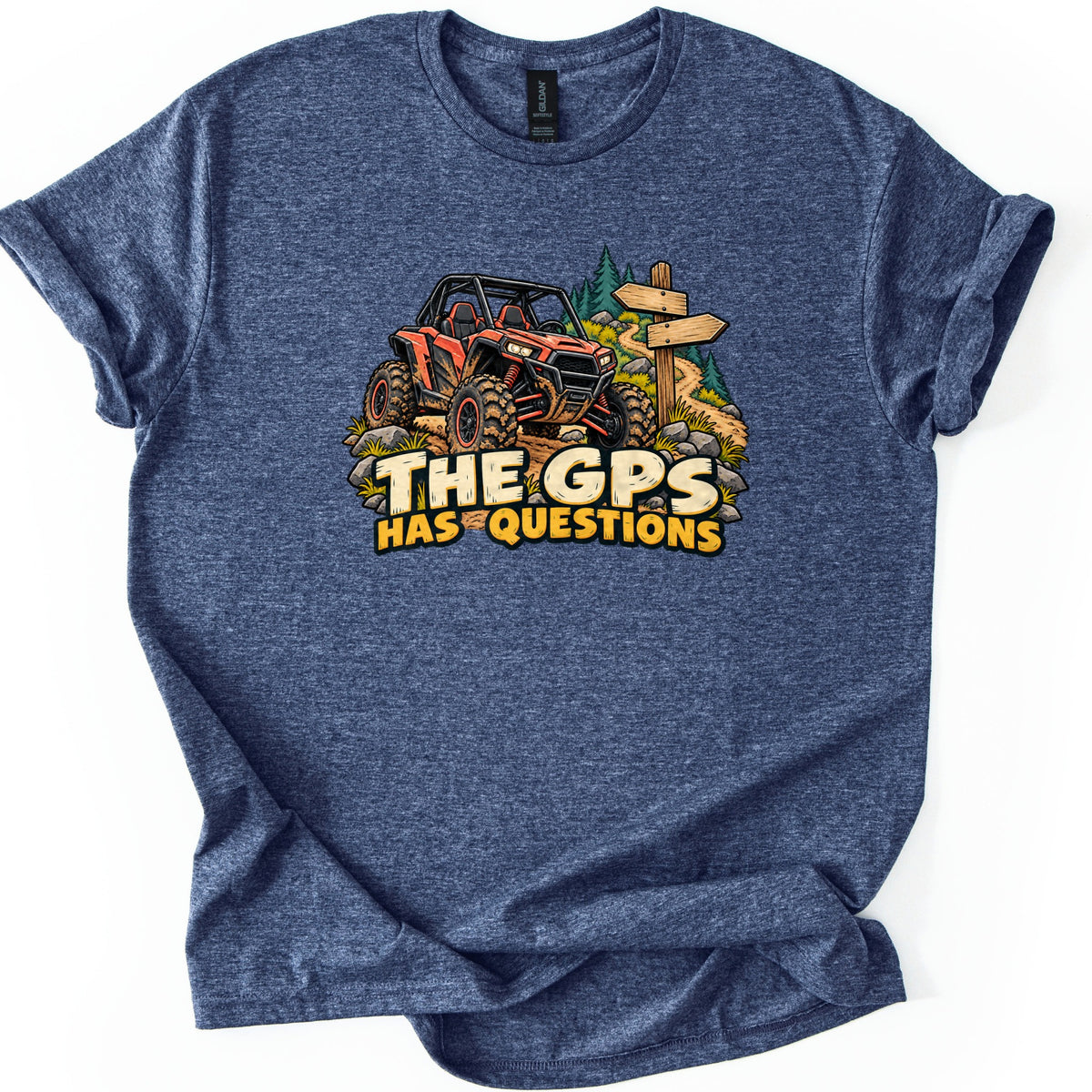 The GPS Has Questions Comfort Colors T-shirt in Heather Navy, laid flat. A muddy orange off-road side-by side sits on a dirt trail with rocks, pine trees and a wooden signpost above the words The GPS Has Questions. The shirt has rolled sleeves on a white background.
