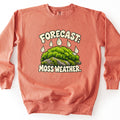 Forecast Moss Weather Comfort Colors crewneck sweatshirt in Terracotta, laid flat. The front shows a mound of bright green moss on a gray rock with cream raindrops falling on it, between the words Forecast: above and Moss Weather. below. The sweatshirt lies on a white background.