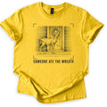 Someone Ate The Wreath Comfort Colors T-shirt in Daisy, laid flat. A pencil-style sketch of a deer on a wooden porch, a sprig of greenery in its mouth, below a bowed wreath on the door, framed by camera viewfinder corners above the words Someone Ate The Wreath.