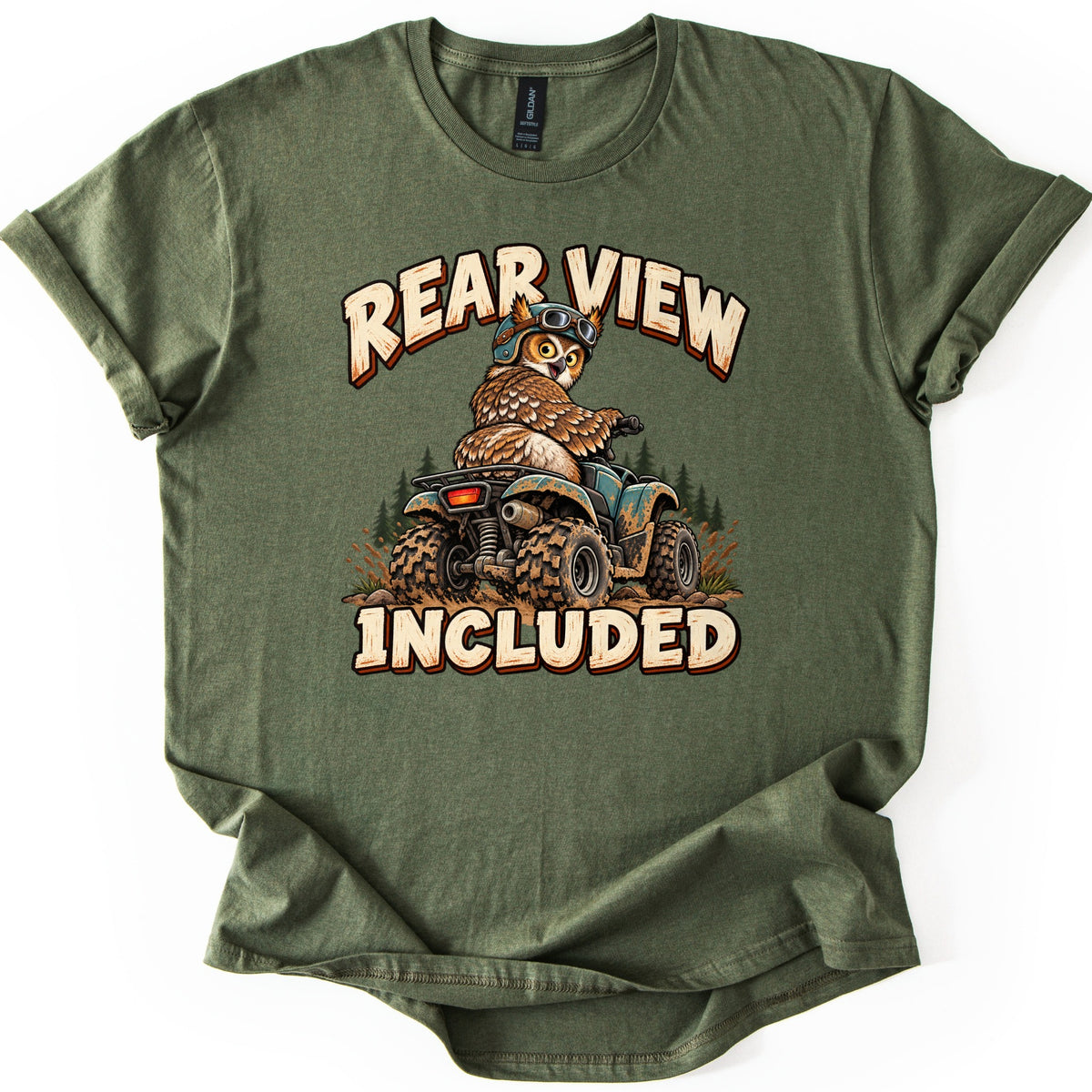 Rear View Included Comfort Colors T-shirt in Military Green, laid flat. A cartoon owl in a helmet and goggles rides a muddy ATV past pine trees, looking back over its shoulder, between the words Rear View Included. The shirt lies on a white surface with rolled sleeves.