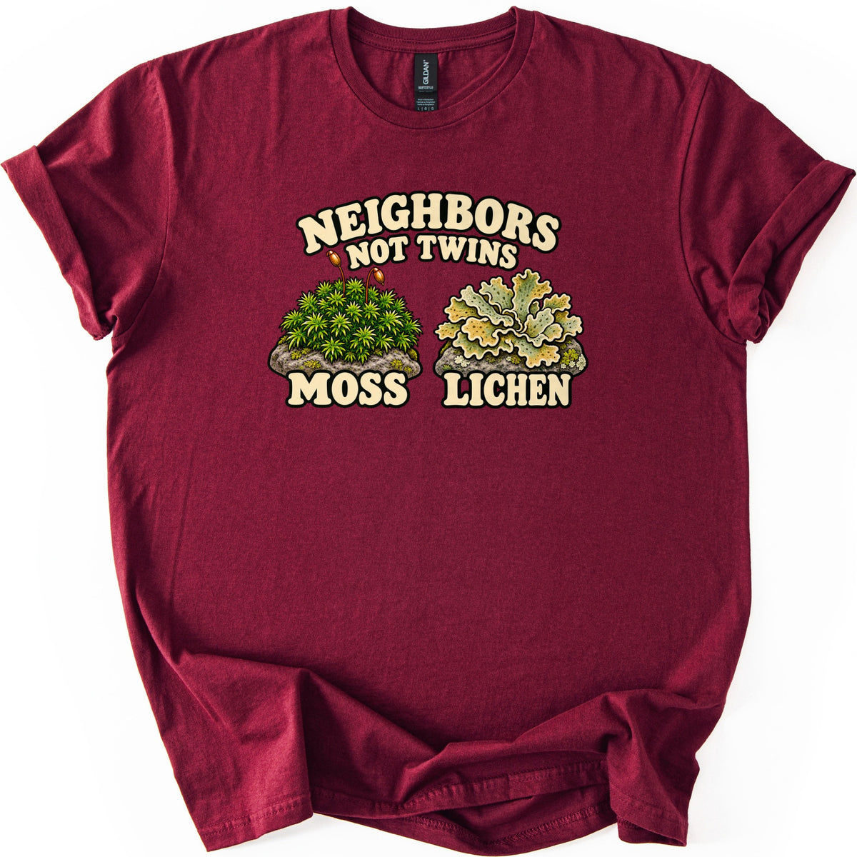 Neighbors Not Twins Comfort Colors T-shirt in Maroon, laid flat. Cream retro letters read Neighbors Not Twins above two rocks, one topped with green moss and two spore stalks labeled Moss, the other with pale green leafy lichen labeled Lichen. Sleeves rolled, on white.