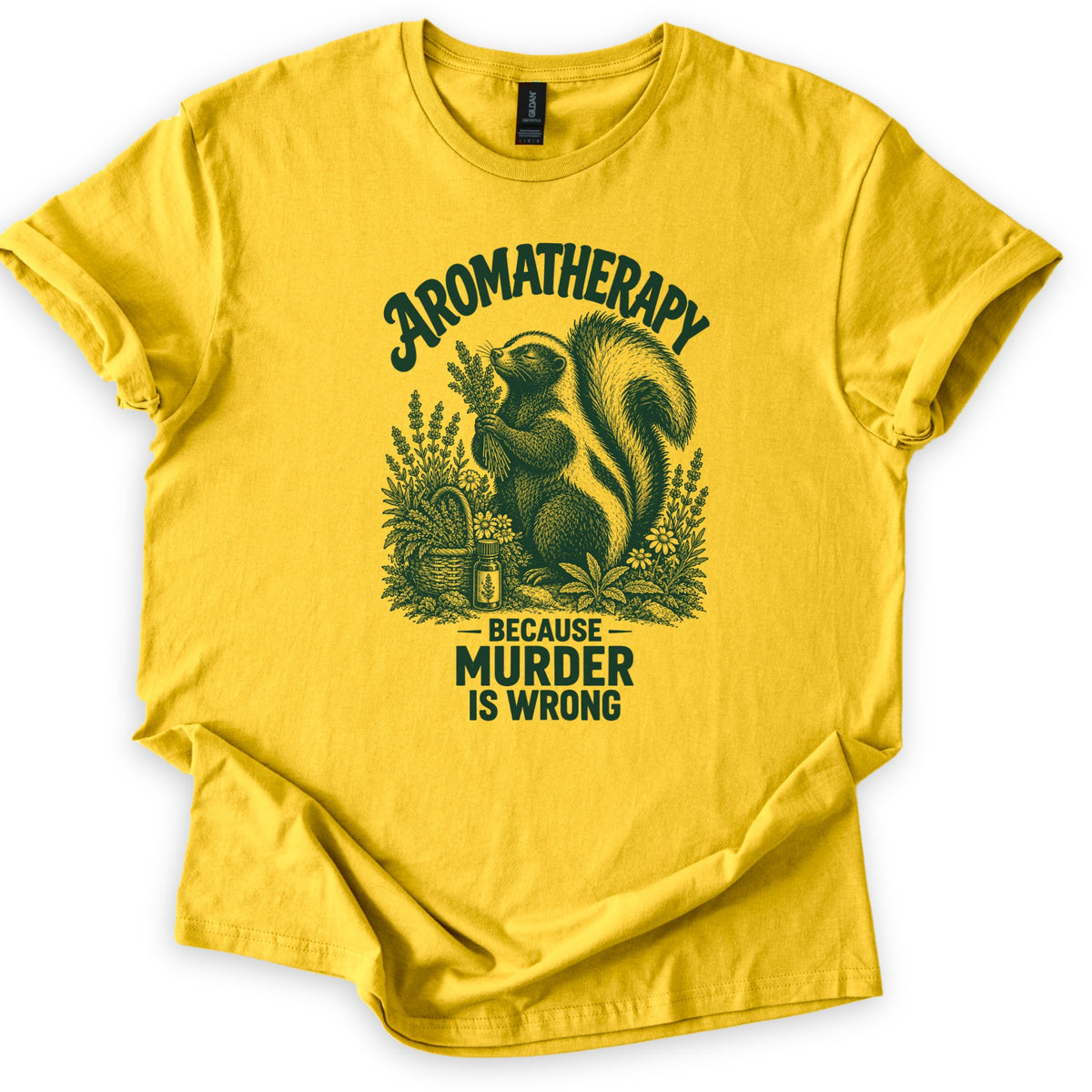 Aromatherapy Murder Skunk Comfort Colors T-shirt in Daisy, laid flat. A dark green skunk sniffs a lavender bundle beside a basket, flowers and an oil bottle, under the word Aromatherapy and above Because Murder Is Wrong. Sleeves are cuffed on a white background.