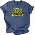 Tucked in by the Forest Comfort Colors T-shirt in Heather Navy, laid flat. A sleeping gray mouse with pink ears lies under a blanket of green moss in a hollow log, between cream words reading Tucked in By the Forest. The shirt has rolled sleeves on a white background.