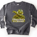 A Whole World in a Dewdrop Comfort Colors crewneck sweatshirt in Pepper, laid flat. A painted dewdrop rests on a green fern-like moss branch, the drop reflecting tiny evergreen sprigs, above cream lettering reading A Whole World in a Dewdrop. The sweatshirt lies on a white background.