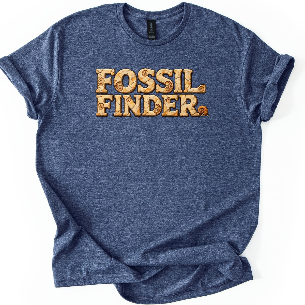 Fossil Finder Comfort Colors T-shirt in Heather Navy, laid flat. The words Fossil Finder in chunky cracked tan stone letters with ammonite fossil imprints, and a small ammonite shell as the period. The shirt has cuffed sleeves on a white background.