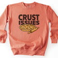 Crust Issues Comfort Colors crewneck sweatshirt in Terracotta, laid flat. The words Crust Issues in large dark brown letters sit above a cartoon lattice-top pie with a wooden rolling pin beside it. The sweatshirt lies on a plain white surface.