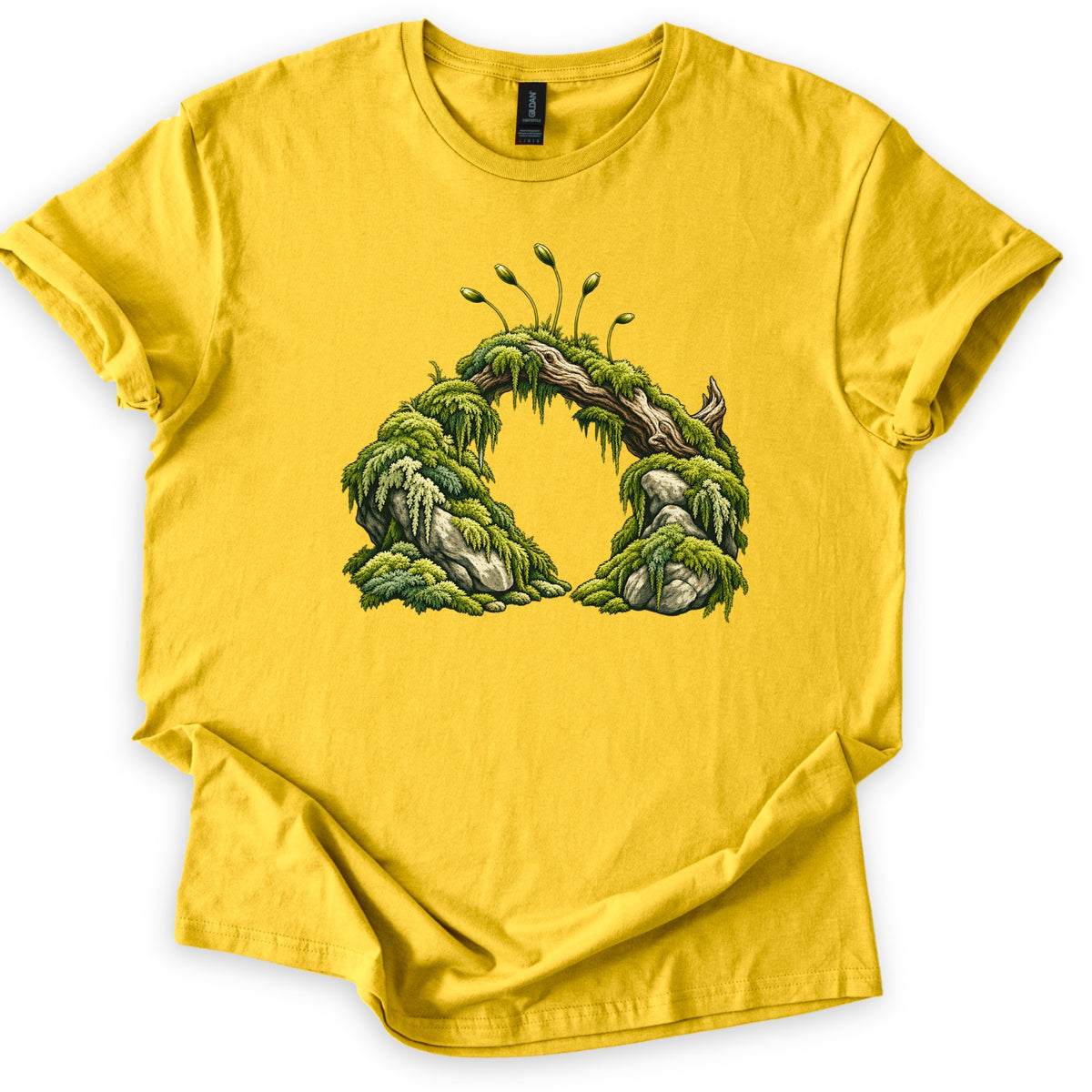 Moss Arch Comfort Colors T-shirt in Daisy, laid flat. A fallen log draped in green moss arches between two mossy boulders, with slender moss spore stalks rising from the top. No words are printed. The sleeves are cuffed and it lies on a white background.