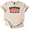 Braking Bumps Arm Day Included Comfort Colors T-shirt in Sand, laid flat. Wavy lettering reads Braking in navy and Bumps in orange over orange wave lines, then Arm Day Included in navy and MTB in orange between dashes. The shirt has rolled sleeves on a white background.