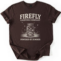 Firefly Lighting Company Comfort Colors T-shirt in Dark Chocolate, laid flat. Cream lettering reads Firefly Lighting Company above a sketched mason jar of glowing fireflies on a wooden table, with Powered by Summer below. The sleeves are rolled, on a white background.