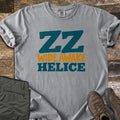 ZZ Wide Awake Comfort Colors T-shirt in Grey, laid flat. Large teal letters read ZZ, with Wide Awake in orange and Helice in teal below. The sleeves are rolled on a rustic wood floor beside olive cargo pants and brown leather hiking boots.