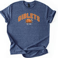 Giblets Comfort Colors T-shirt in Heather Navy, laid flat. Arched orange varsity-style letters read GIBLETS above a cartoon roast turkey on a platter, with EST. 1621 in white below. The shirt has rolled sleeves and lies on a white background.
