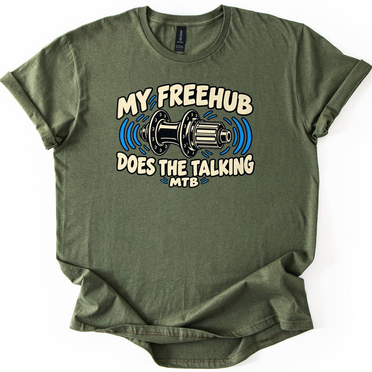 Freehub Does the Talking Comfort Colors T-shirt in Military Green, laid flat. A black and cream rear bicycle hub with blue sound-wave lines sits between the words My Freehub Does the Talking, with MTB below. The sleeves are rolled and it lies on a white background.