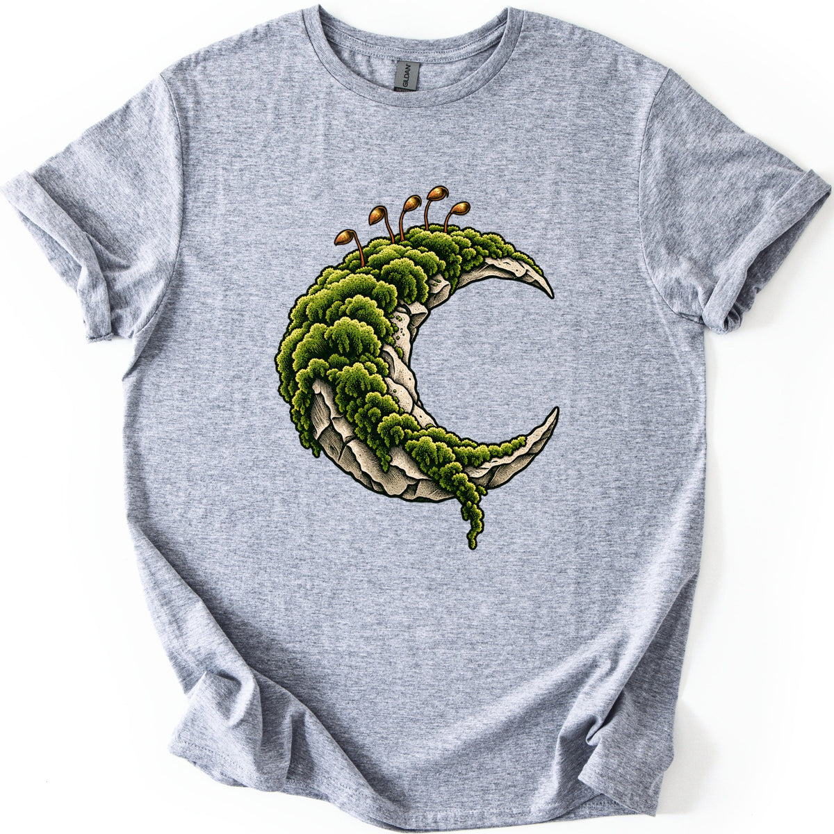 Moss Moon Comfort Colors T-shirt in Sport Grey, laid flat. A pale stone crescent moon covered in thick green moss, with thin orange moss sprouts rising from the top and moss trailing off the lower tip. No words. The sleeves are rolled on a white background.