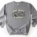 One More Loop Comfort Colors crewneck sweatshirt in Grey, laid flat. The words One More Loop in cream lettering with dark teal shadows surround an infinity-shaped dirt tire track, with a rider on an ATV and a pine tree. Laid flat on a white background.