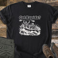 Got Rapids Comfort Colors T-shirt in Black, laid flat. The words Got Rapids? above two smiling rafters in helmets and life vests riding a raft through splashing whitewater, one holding a paddle overhead. Set on wood planks with olive hiking pants and brown boots.