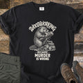Woodworking Because Murder Is Wrong Comfort Colors T-shirt in Black, laid flat. A cream sketch of a beaver gnawing a log on a woodpile, under the arched words Woodworking and above Because Murder Is Wrong. Olive cargo pants and brown hiking boots sit beside it on weathered wood planks.