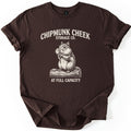 Chipmunk Cheek Storage Co Comfort Colors T-shirt in Dark Chocolate, laid flat. A cream engraving-style chipmunk with stuffed cheeks, holding a nut on a log, sits below the words Chipmunk Cheek Storage Co. and above At Full Capacity. The sleeves are rolled on a white surface.