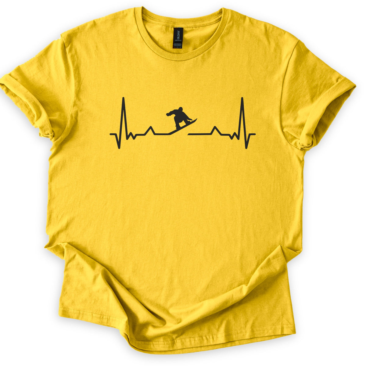 Snow Boarder Pulse II Comfort Colors T-shirt in Daisy, laid flat. A black heartbeat line runs across the chest, with a snowboarder silhouette carving through a gap in the line; there are no words. The shirt lies on a white surface with its sleeves cuffed.