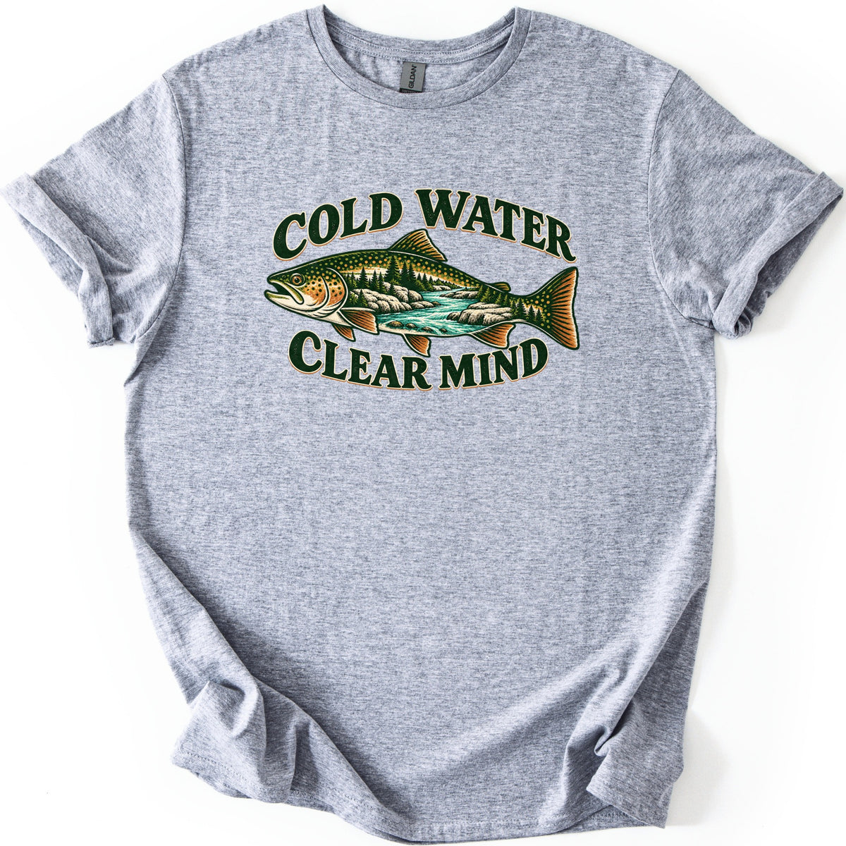 Cold Water Clear Mind Comfort Colors T-shirt in Sport Grey, laid flat. A speckled trout whose body holds a scene of pine trees, rocks and a turquoise river sits between the words Cold Water and Clear Mind in dark green. The sleeves are rolled on a plain white background.