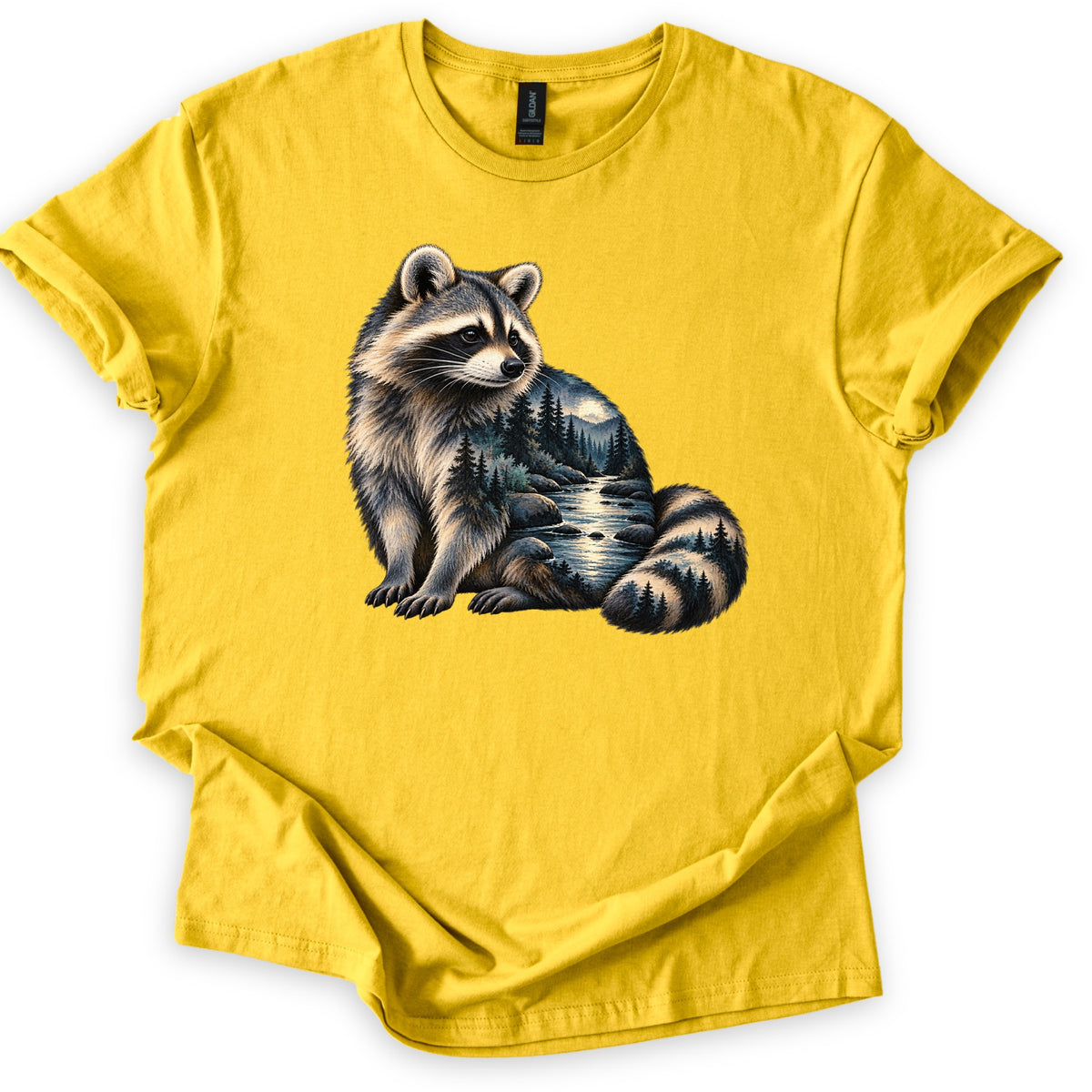 Raccoon Night Creek Comfort Colors T-shirt in Daisy, laid flat. A realistic seated raccoon whose body shows a night scene of a creek, rocks, pine trees and a glowing moon over mountains, with pines in its striped tail. No words. Sleeves rolled, laid on a white surface.