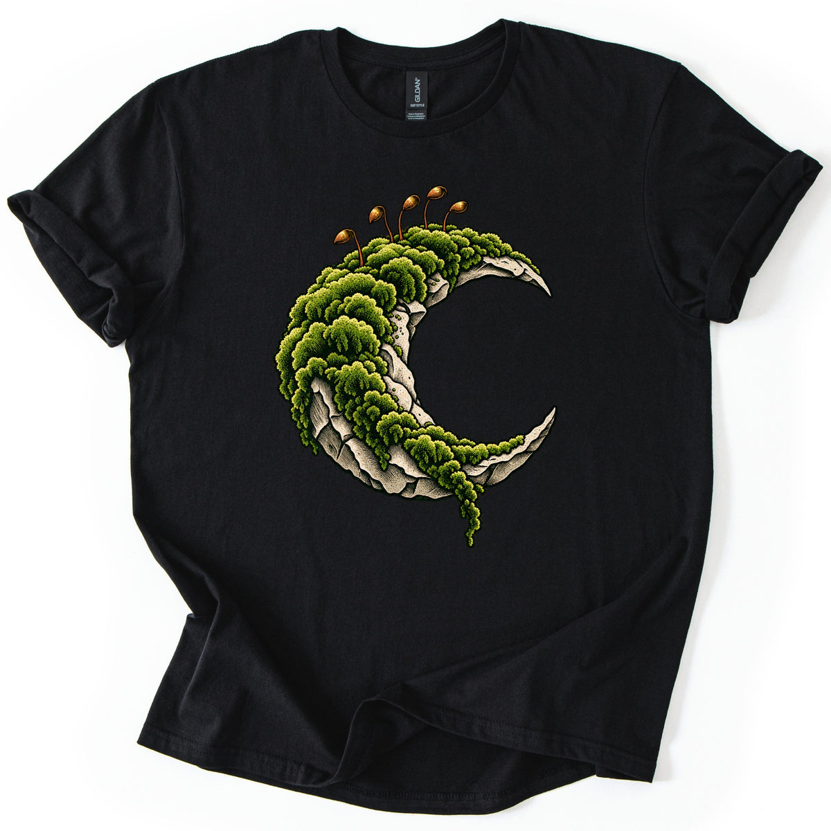 Moss Moon Comfort Colors T-shirt in Black, laid flat. A pale stone crescent moon covered in thick green moss, with thin orange moss sprouts rising from the top and moss trailing off the lower tip. No words. The sleeves are rolled on a white background.