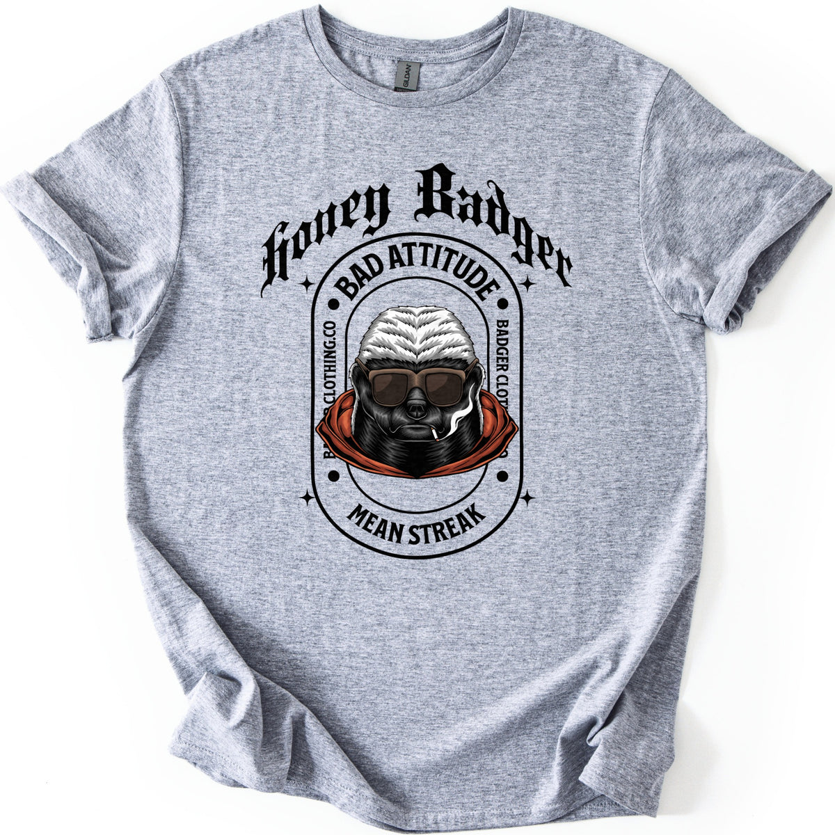 Bad Vibes Badger Comfort Colors T-shirt in Sport Grey, laid flat. Black print: Honey Badger in gothic letters over an oval badge reading Bad Attitude, Badger Clothing.co and Mean Streak around a honey badger in sunglasses and an orange hood, smoking a cigarette. On a white background.